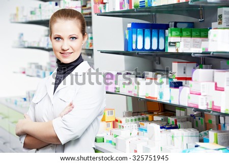 Pharmaceutical industry. Cheerful pharmacist chemist woman standing in pharmacy drugstore