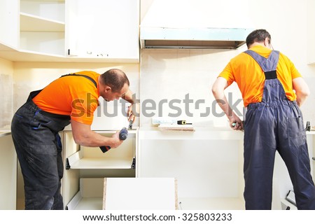 Craftsman kitchen carpenter workers at kitchen furniture set installation service work
