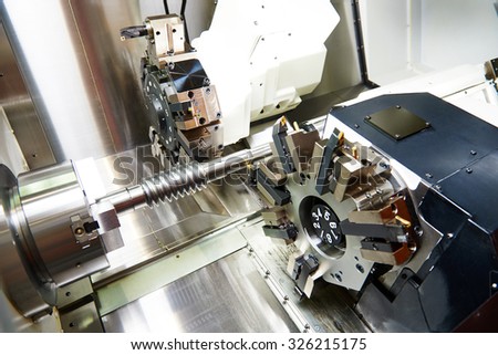 metalworking  industry: cutting tool processing steel metal shaft on lathe machine in workshop