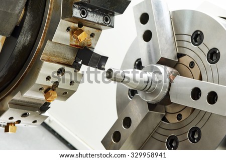 metalworking  industry. cutting process of steel metal shaft on turning lathe machine in workshop.