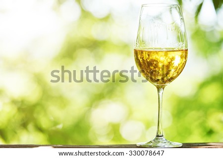 Glass of Chardonnay, Sauvignon or Rkatsiteli white wine over outdoors background