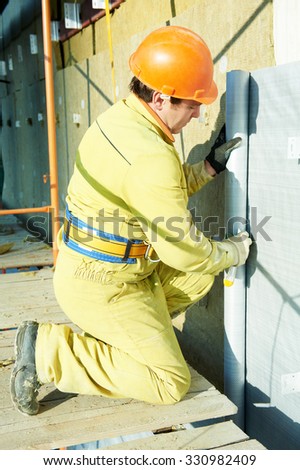 facade plasterer builder at outdoor building external wall insulation with wind protection film