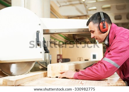 process of carpenter worker with circular saw machine at wood beam cross cutting during furniture manufacture