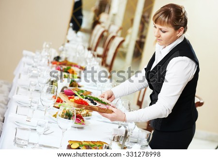 Restaurant catering services. Two female waitress serving banquet table