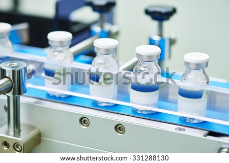 pharmaceutical industry. Production line machine conveyor with glass bottles ampoules at factory