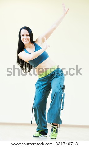 female dance fitness instructor doing zumba dancing exercises in gym