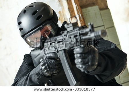 military industry. Portrait of special forces or anti-terrorist police soldier, private contractor armed with assault rifle ready to attack during clean-up operation, mission