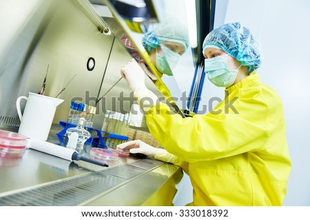 female science researcher in protective uniform and equipment works with dangerous hazard virus material at microbiology laboratory