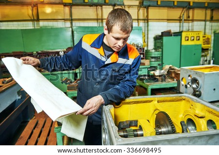 Adult experienced industrial worker assembling the reduction gear box on production line manufacturing workshop