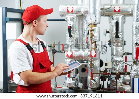 Technician maintenance repairman engineer inspecting heating system in boiler room