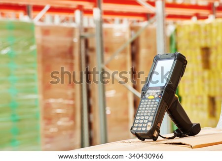 Bluetooth bar code scanner in front of modern warehouse