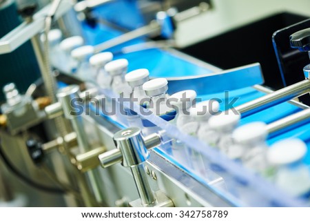 pharmaceutical industry. Production line machine conveyor with glass bottles ampoules at factory