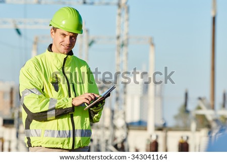 engineer builder with laptop computer at construction site near power plant