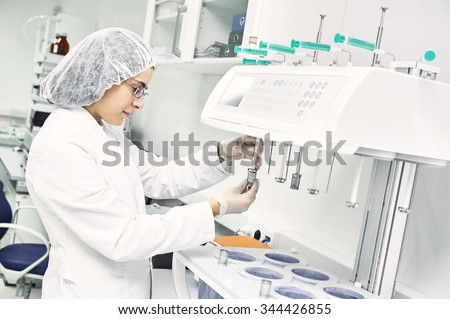 Pharmaceutical scientific  female researcher in protective uniform working with dissolution tester at pharmacy industry manufacture factory laboratory