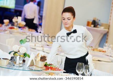 waitress occupation. Young woman with food on dishes servicing in restaurant during catering the event