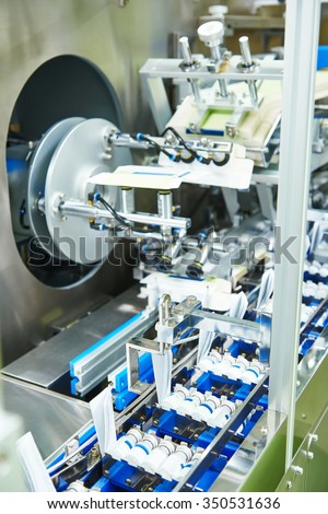 pharmaceutical industry. Line machine conveyer for packaging glass bottles ampoules in boxes at pharmacy industry manufacture factory