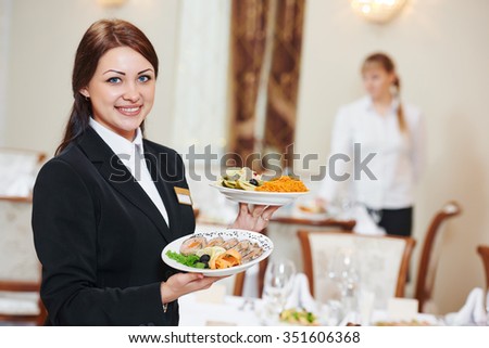 Restaurant catering services. Waitress with food dish serving banquet table