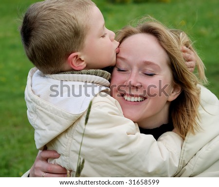 little boy kissing his mother forehead outdoor