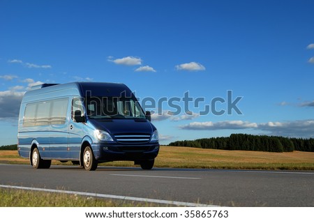 blue minibus transporting passengers on highway over blue sky