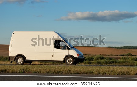 White delivery mini truck moving on the highway over blue sky. See my portfolio for trucks and lorries