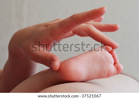 hand of young woman measure the foot of a child