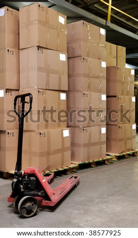 Group of carton boxes and manual fork pallet truck in warehouse