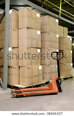 Group of carton boxes and manual fork pallet truck in warehouse