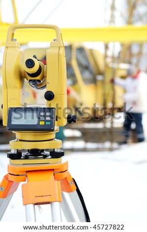 Land surveyor equipment theodolite at a construction site in winter
