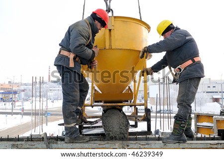 construction building workers at construction site pouring concrete in form