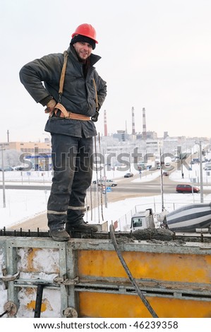 Builder worker in workwear standing on framework for concrete pouring
