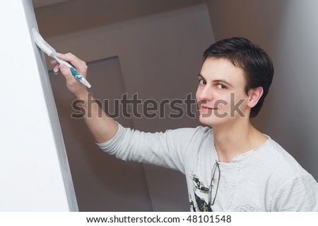 Painter worker hand at decoration work painting a wall with brush
