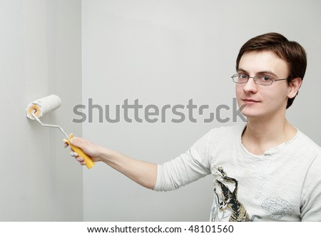 Painter worker hand at decoration work painting a wall with roller