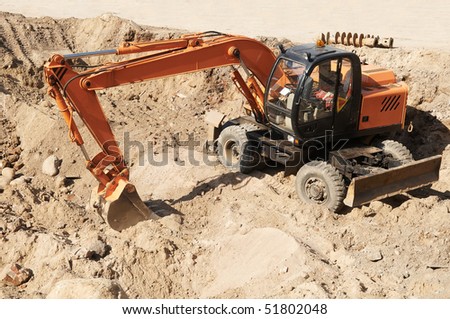 Excavator Loader standing in sandpit with pulled down bucket