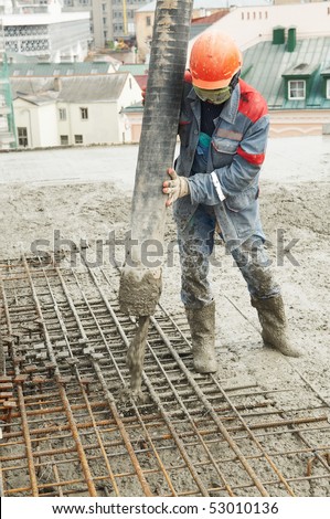 builder worker aiming pump tube during concrete pouring process