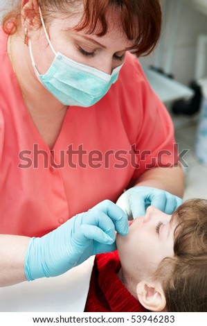 orthodontic doctor examine teeth and gums of little girl jaw