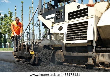 Young builder and Asphalt spreader during Road street repairing works
