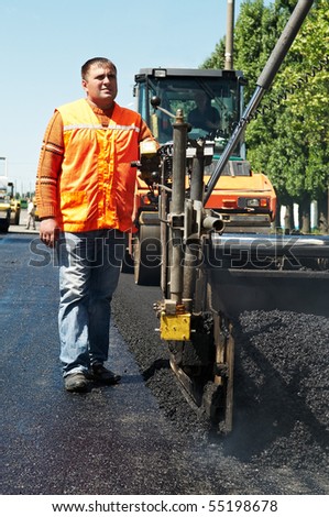 Young builder on Asphalting paver machine during Road street repairing works