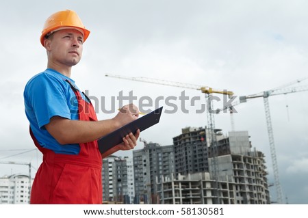 One builder worker with clipboard inspecting construction site