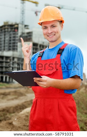 One smiley builder worker with clipboard and finger pointing up at construction site
