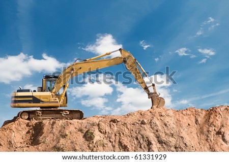 loader excavator in open sand mine over scenic blue sky