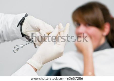 medic hands in protective gloves with anaesthesia syringe and Scaring patient out of focus