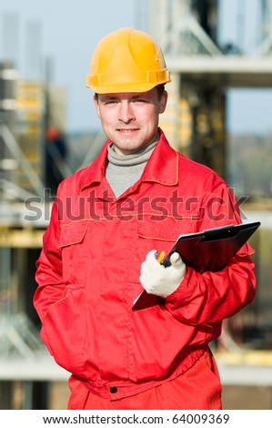 builder worker inspector with clipboard in front of building under construction
