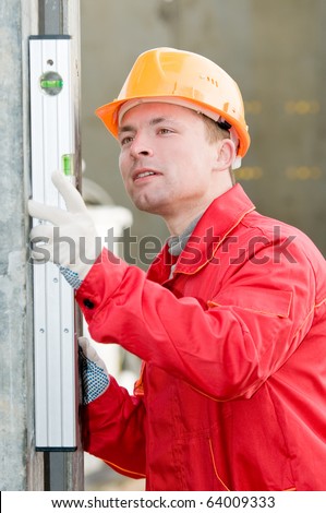 builder worker checking vertical with digital level tool at construction site