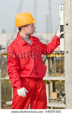 builder worker checking vertical with digital level tool at construction site
