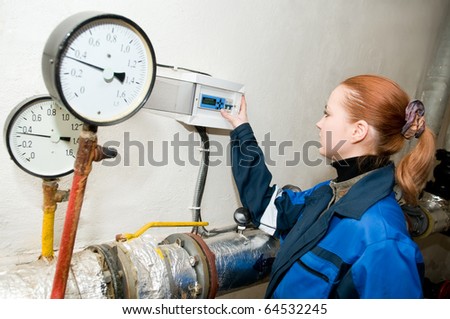 woman engineer checking technical data of heating system equipment in a boiler room