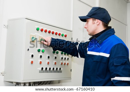 One electrician working on a industrial panel adjusting voltage by toggle switch