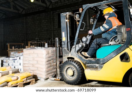 forklift loader at warehouse indoors stacking cement packs to stockpiles