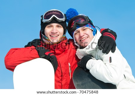 two smiley happy sportsman with snowboards at winter outdoor