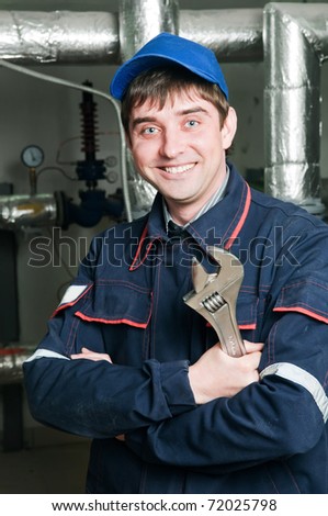 Cheerful maintenance engineer of heating system equipment in a boiler room
