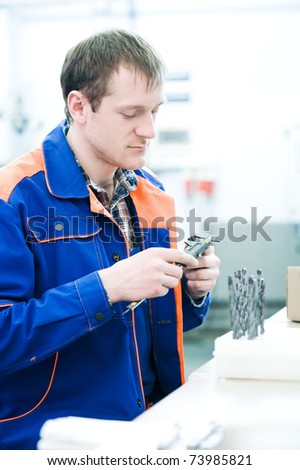 mechanical technician measuring detail after cnc milling cutting machine center at tool workshop